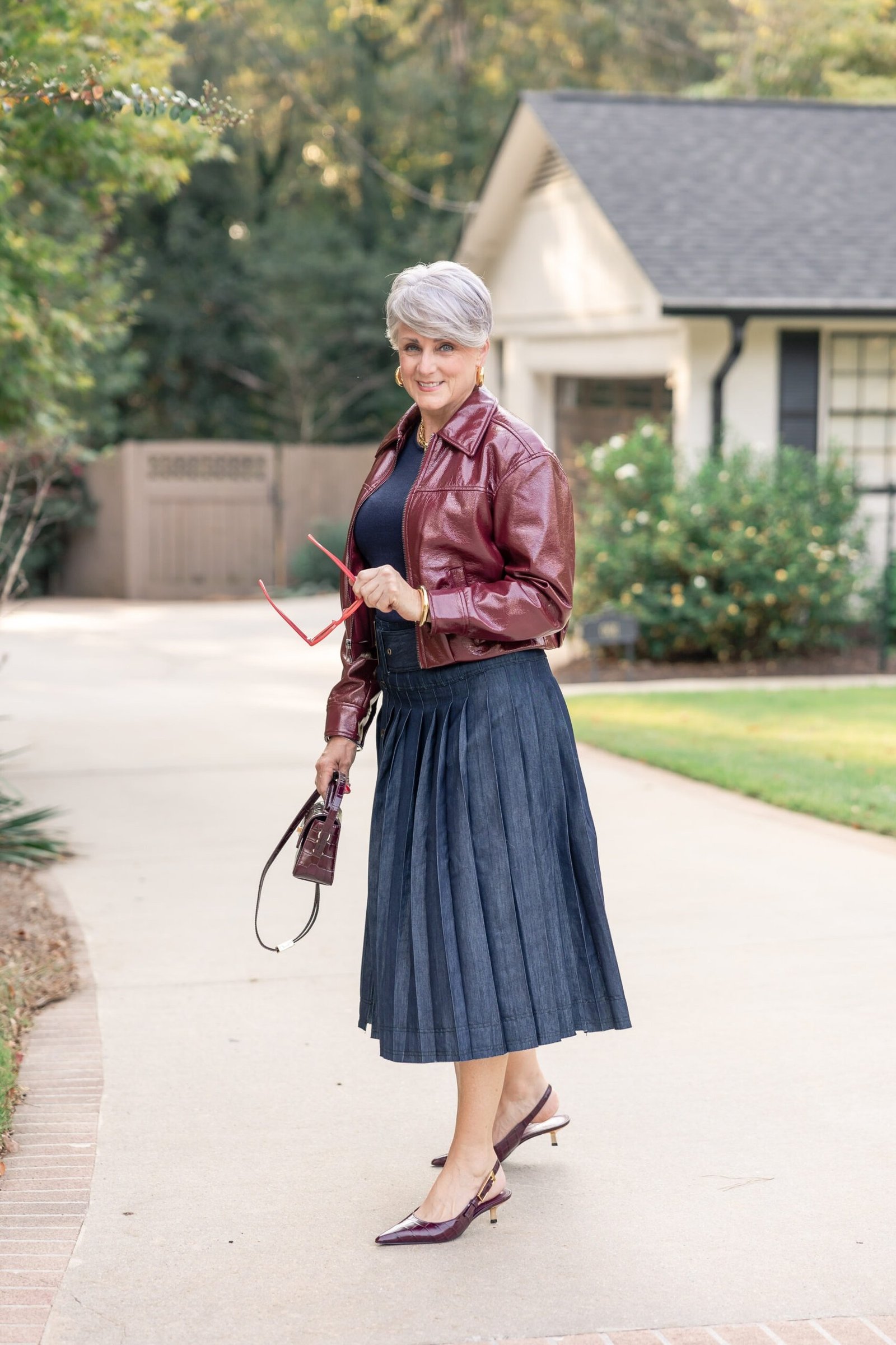 Burgundy Leather Jacket With Navy Pleated Skirt - flattering outfit idea for women over 50, how to dress better over 50