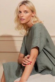 Sage green tunic top, seated, neutral interior for women over 60