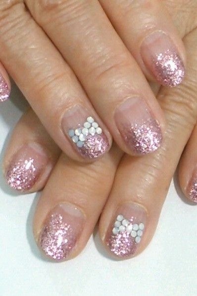 Nail art design for women over 60: pink glitter nails with white flower accents on older hands