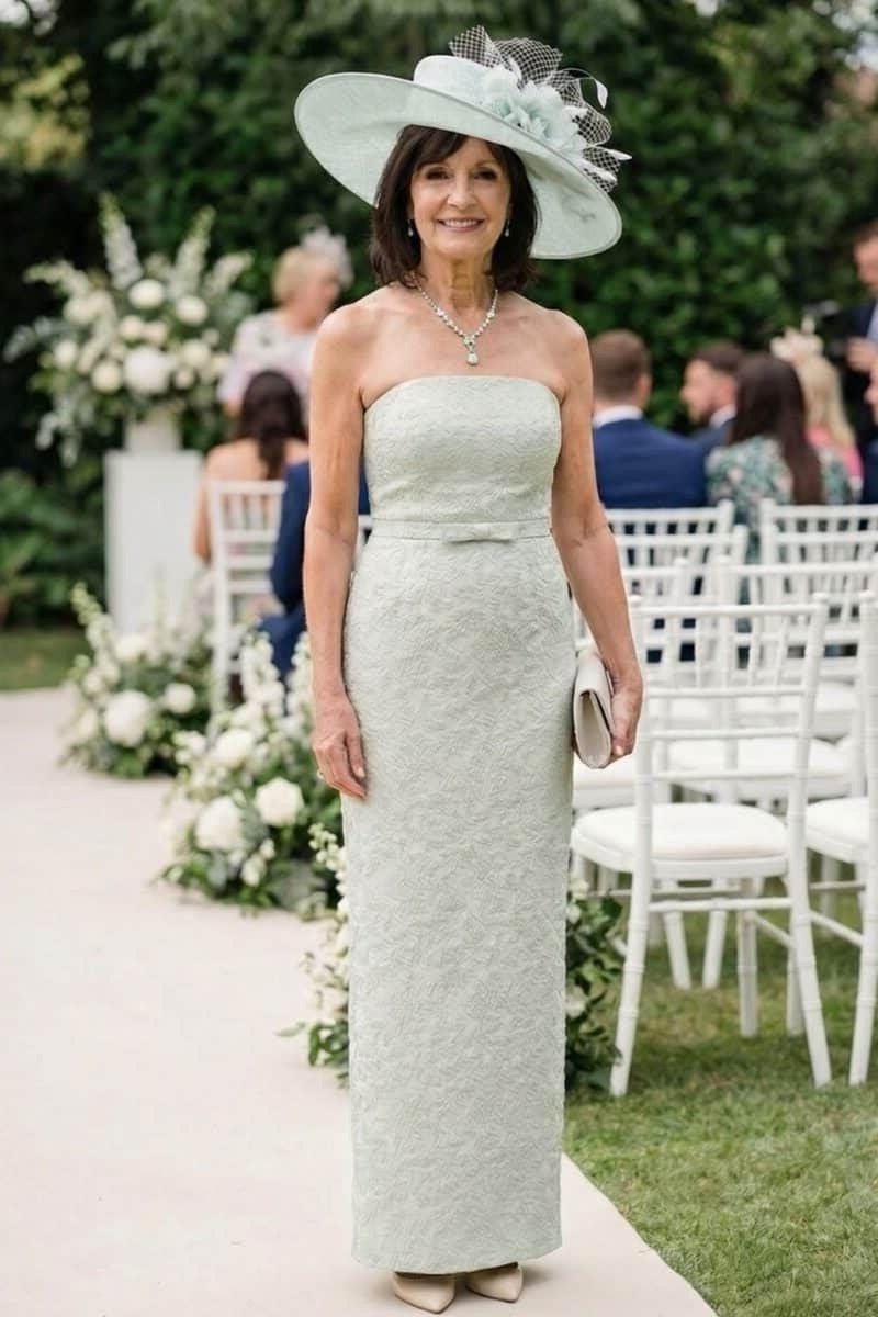 Pale green strapless column gown with white hat, garden wedding - wedding guest outfit for women over 50