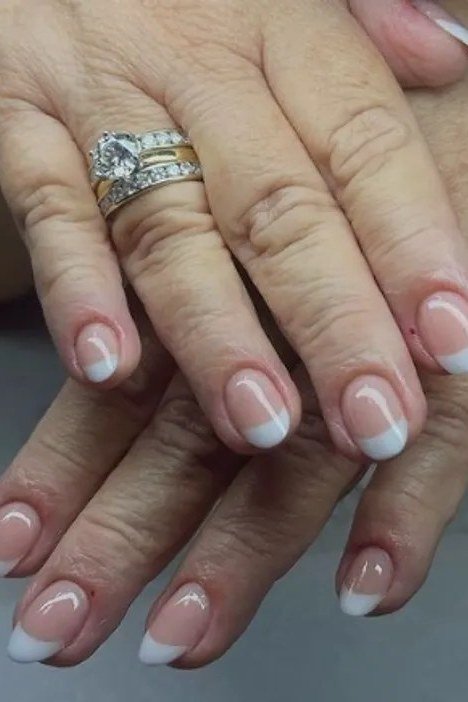 French manicure with a diamond ring on mature hands