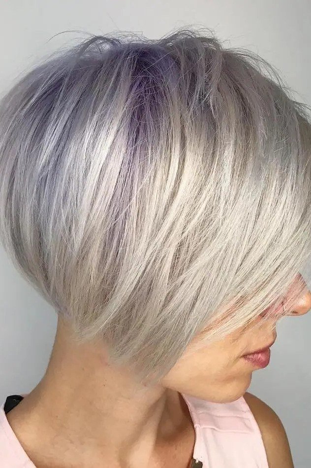 Silver pixie with lavender tint and side-swept fringe - trendy short haircut for older women with fine hair