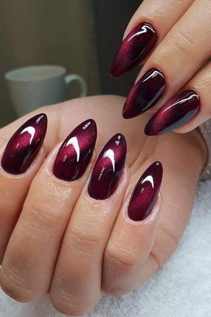Cat-eye burgundy oval, burgundy fall nail idea for women over 60