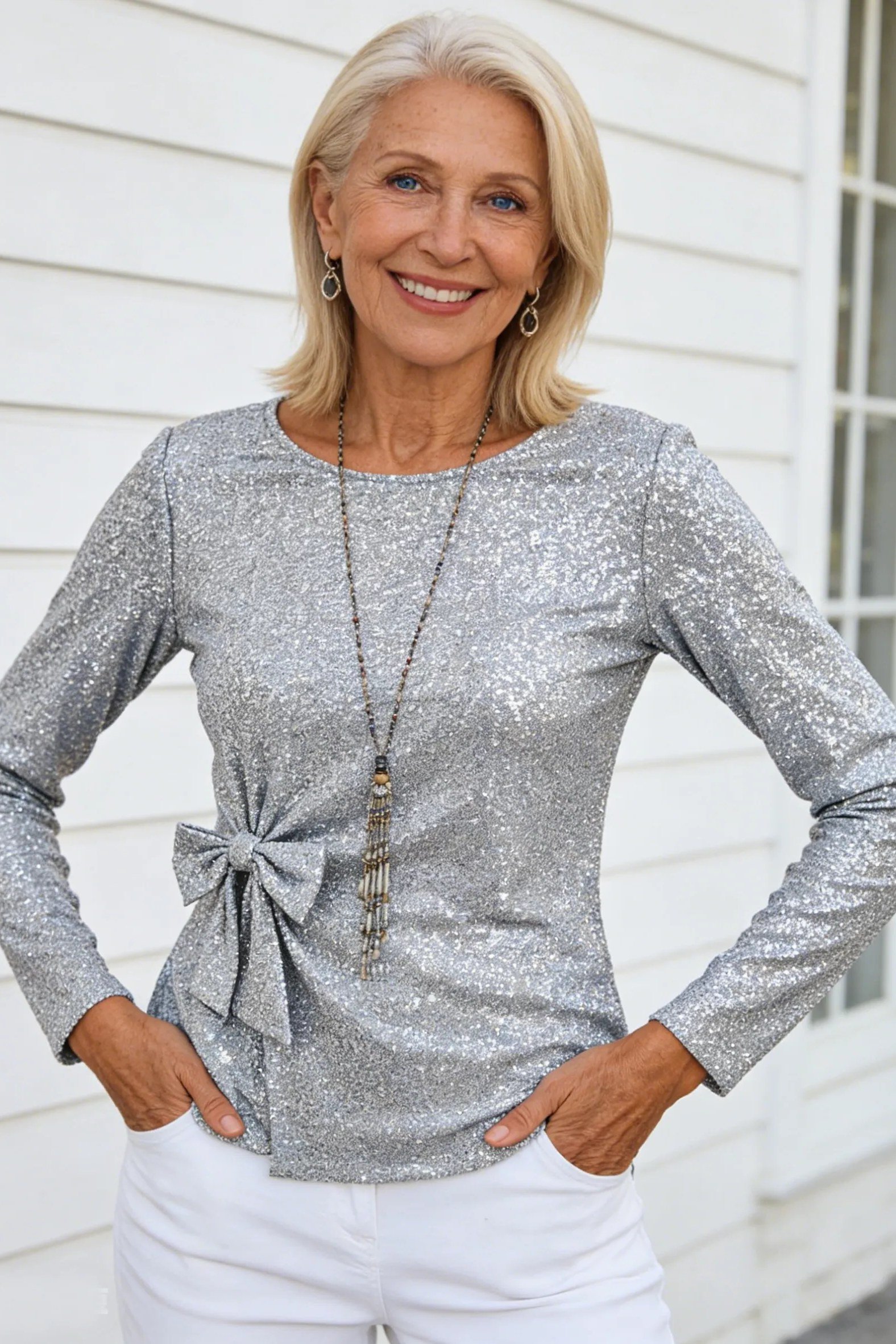 holiday evening outfit for women over 60: silver sequin top with white pants and pendant necklace