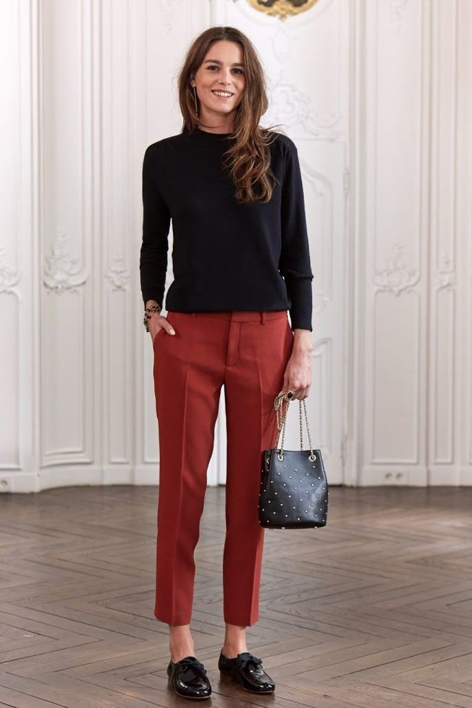 Work outfit for women over 40: black sweater with rust-red trousers