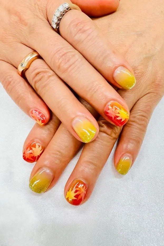 Yellow to orange flame gradient almond nails, glossy bold autumn color.