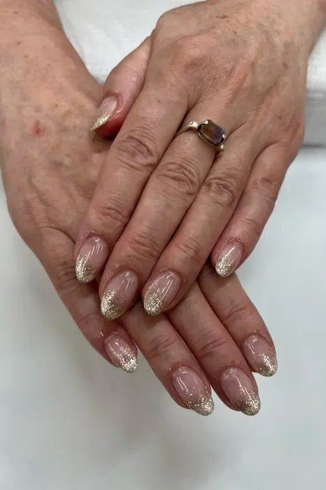 Gold glitter ombre on mature hands, medium almond nails, ombre nail design for women over 60