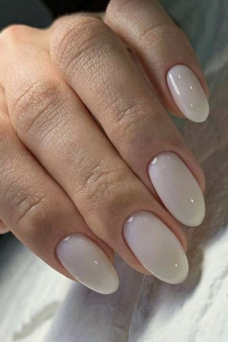 Milky white almond nails on a mature older hand