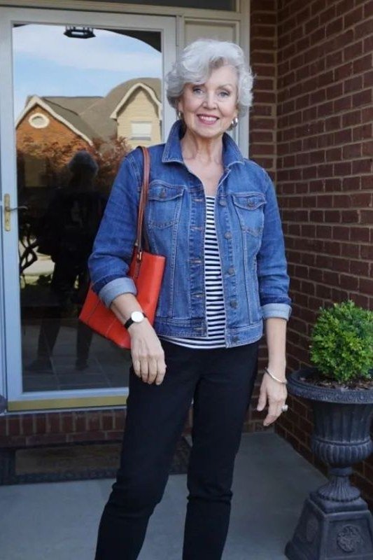 Woman over 50 wearing denim jacket with striped tee and black jeans, everyday casual outfit idea