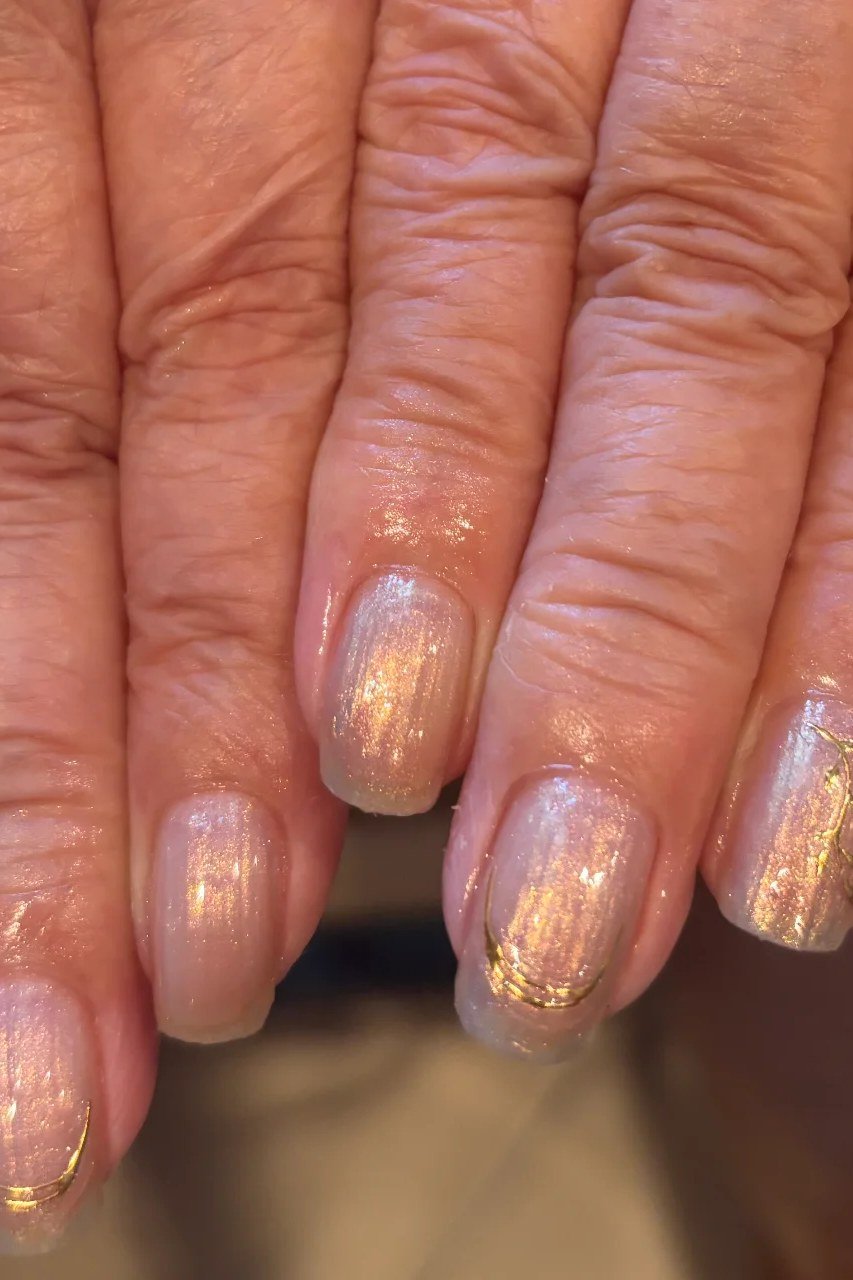 Nude nails with gold shimmer for older women