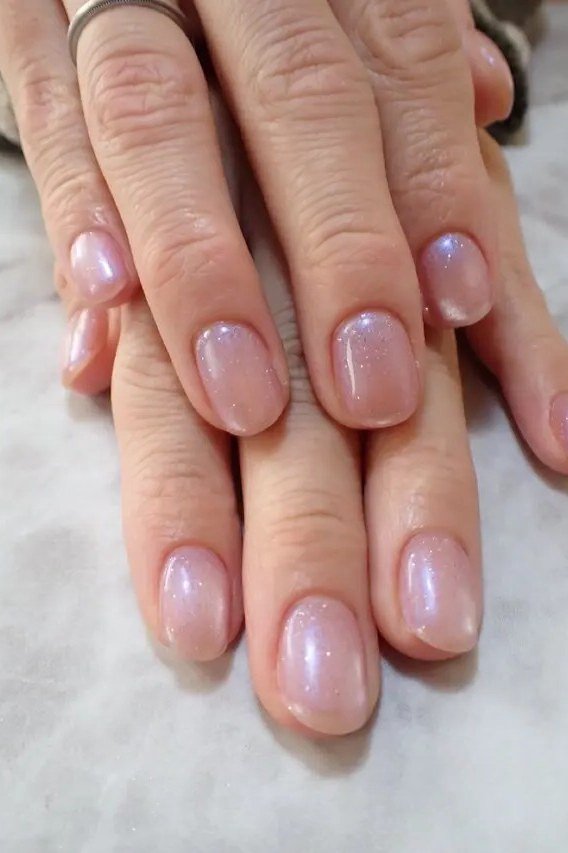 Pearly pink nails on mature hands for women over 50