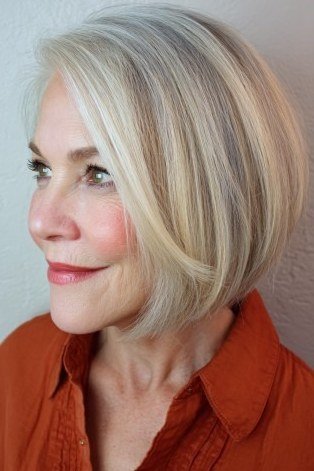 Blonde bob side view, orange shirt, short layered bob hairstyle for women over 60