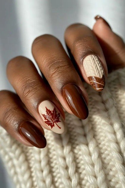 Chocolate brown nails with maple leaf art on dark skin, fall nail design for older women