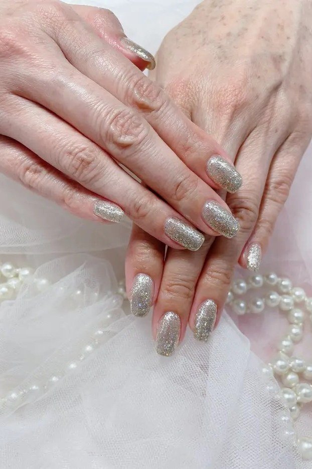 Silver glitter ombre on mature hands, long nails, ombre nail design for women over 60