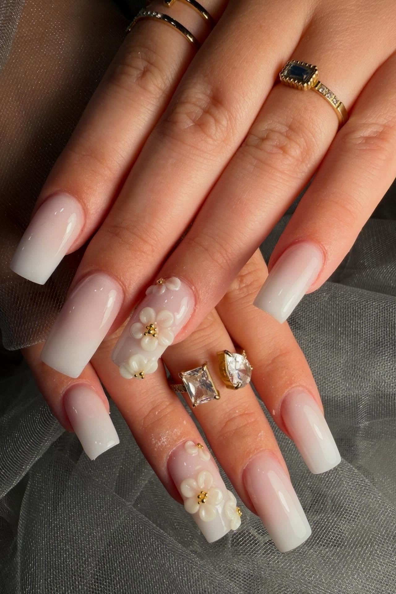 Milky white nails with white and gold floral accents