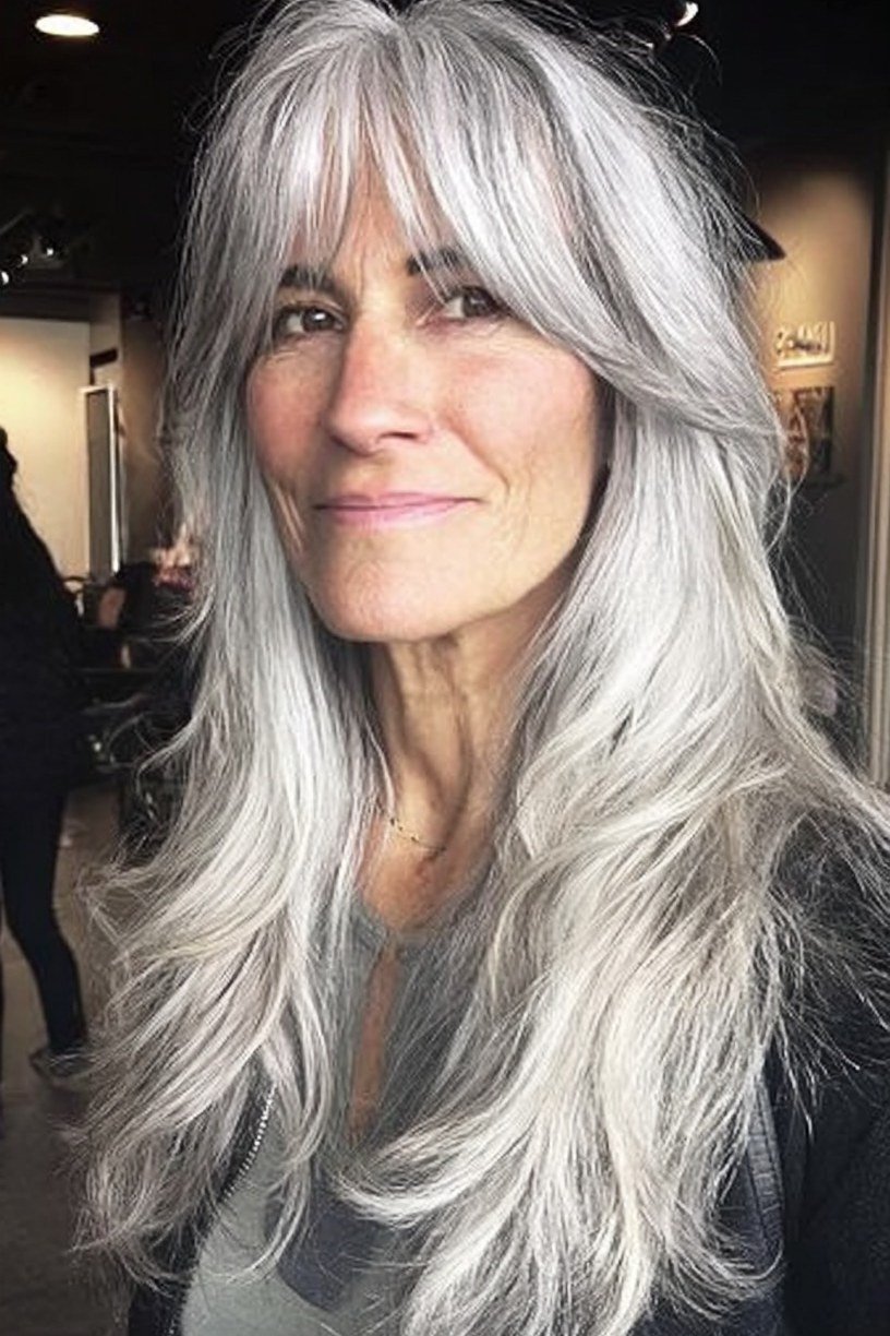 Long silver-gray layered hair with bangs for women over 50