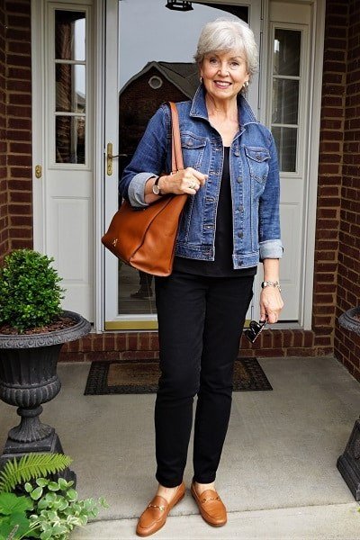 Woman over 50 wearing denim jacket with black jeans and loafers, everyday casual outfit idea