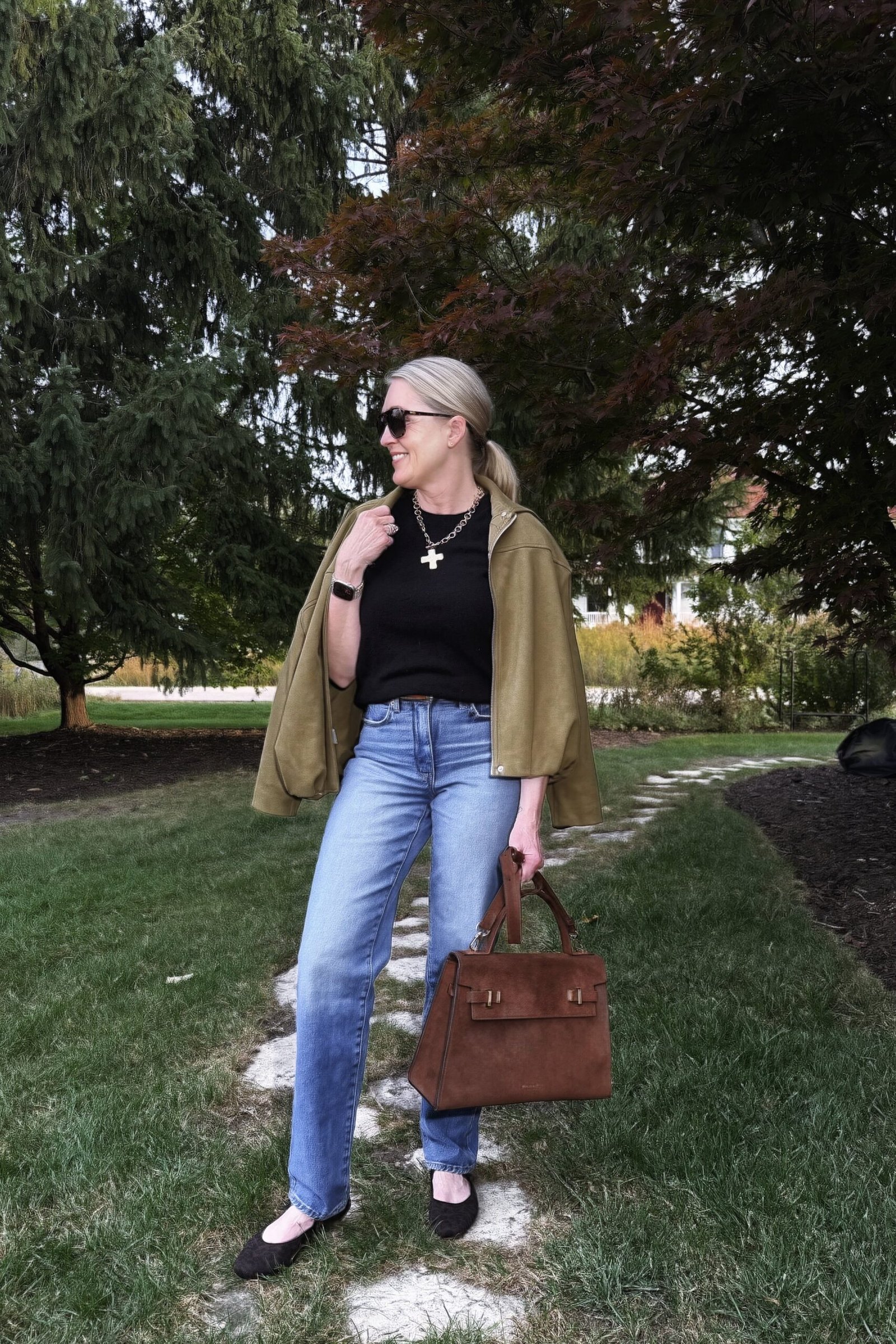Olive Bomber Jacket with a Black Top and Jeans on a woman over 50, fall outfit idea