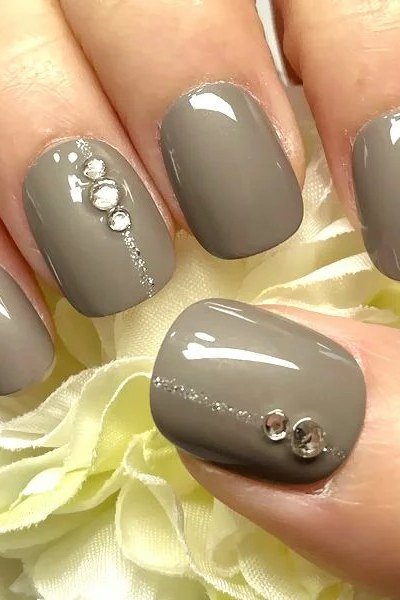 grey taupe nails with rhinestone accents