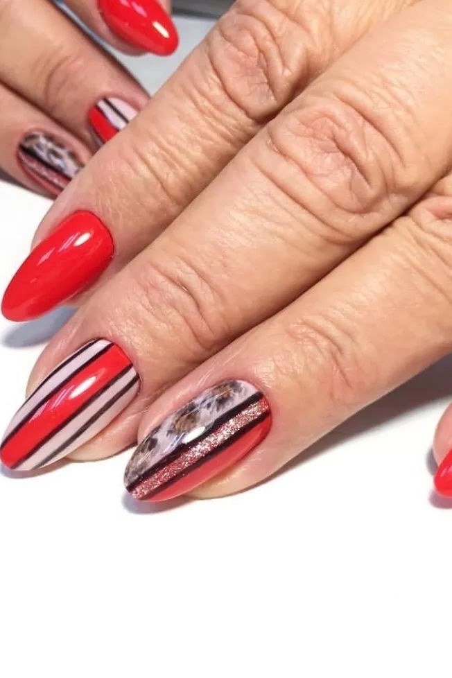 Red nails with striped and marble accent nail art