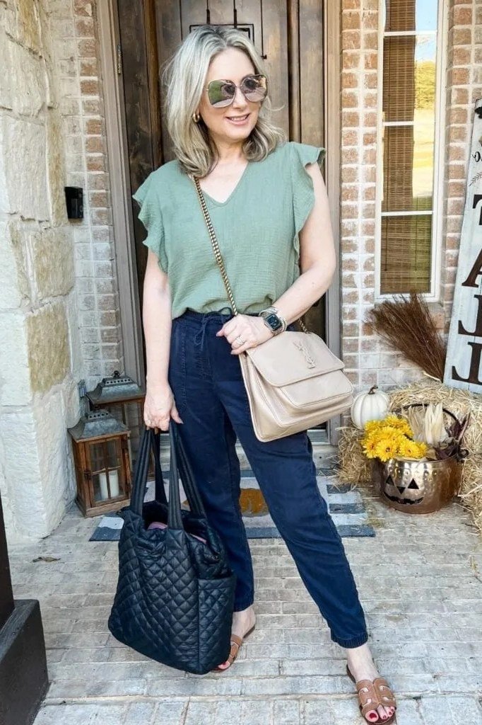 Sage green tee with dark blue jeans and beige shoulder bag