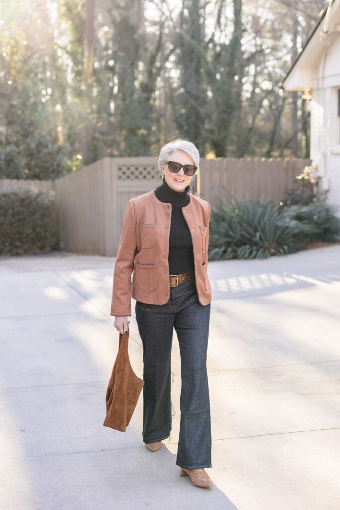 Rust leather jacket with black turtleneck and dark jeans for women over 50