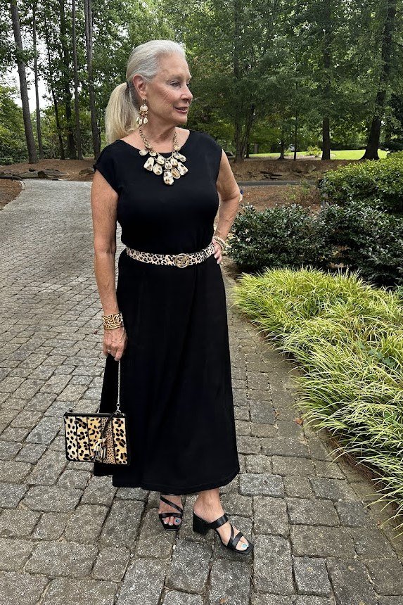 Black sleeveless maxi dress with statement necklace for women over 50