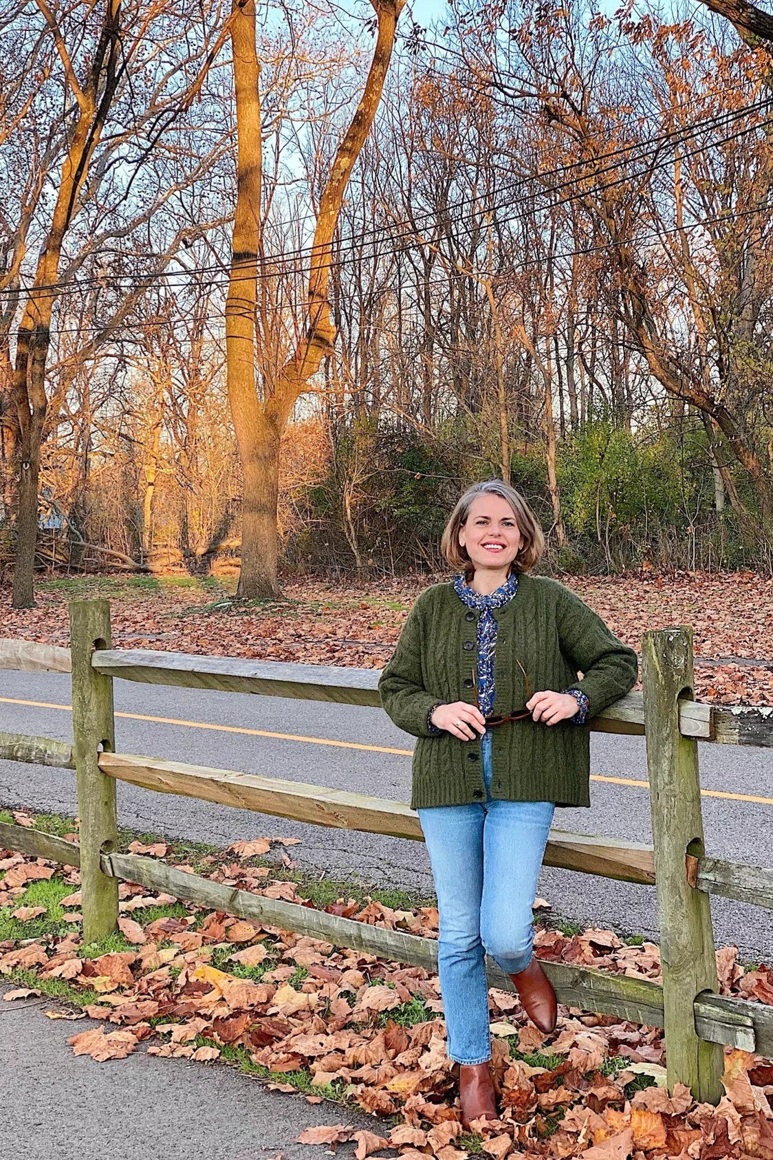 Green knit cardigan with a printed scarf, blue jeans, and brown ankle boots, autumn weekend outfit for women over 40
