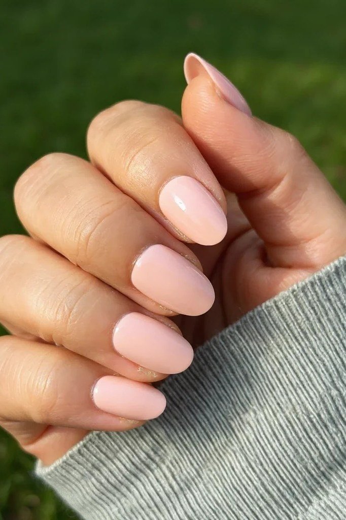 Pink nude nails outdoors with grey sweater