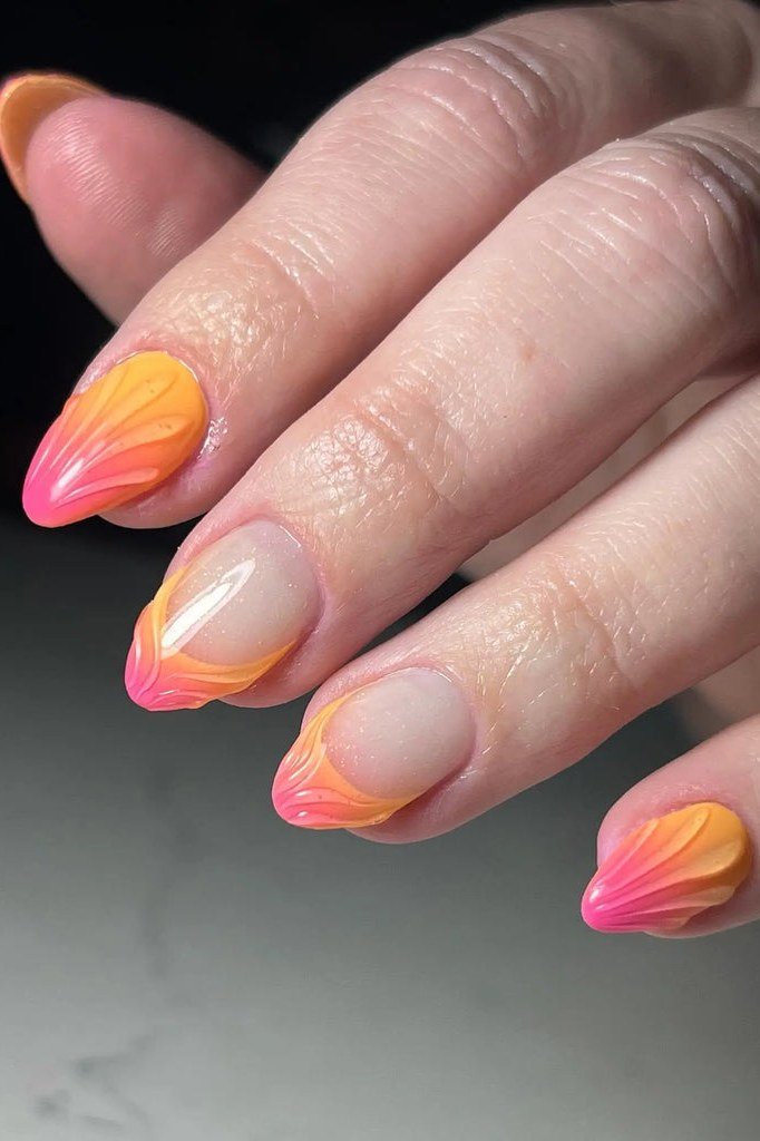 Sunset Sky Gradient Almond Ombre - A nude base fades into swirling orange and pink ombre French tips on these medium almond nails.