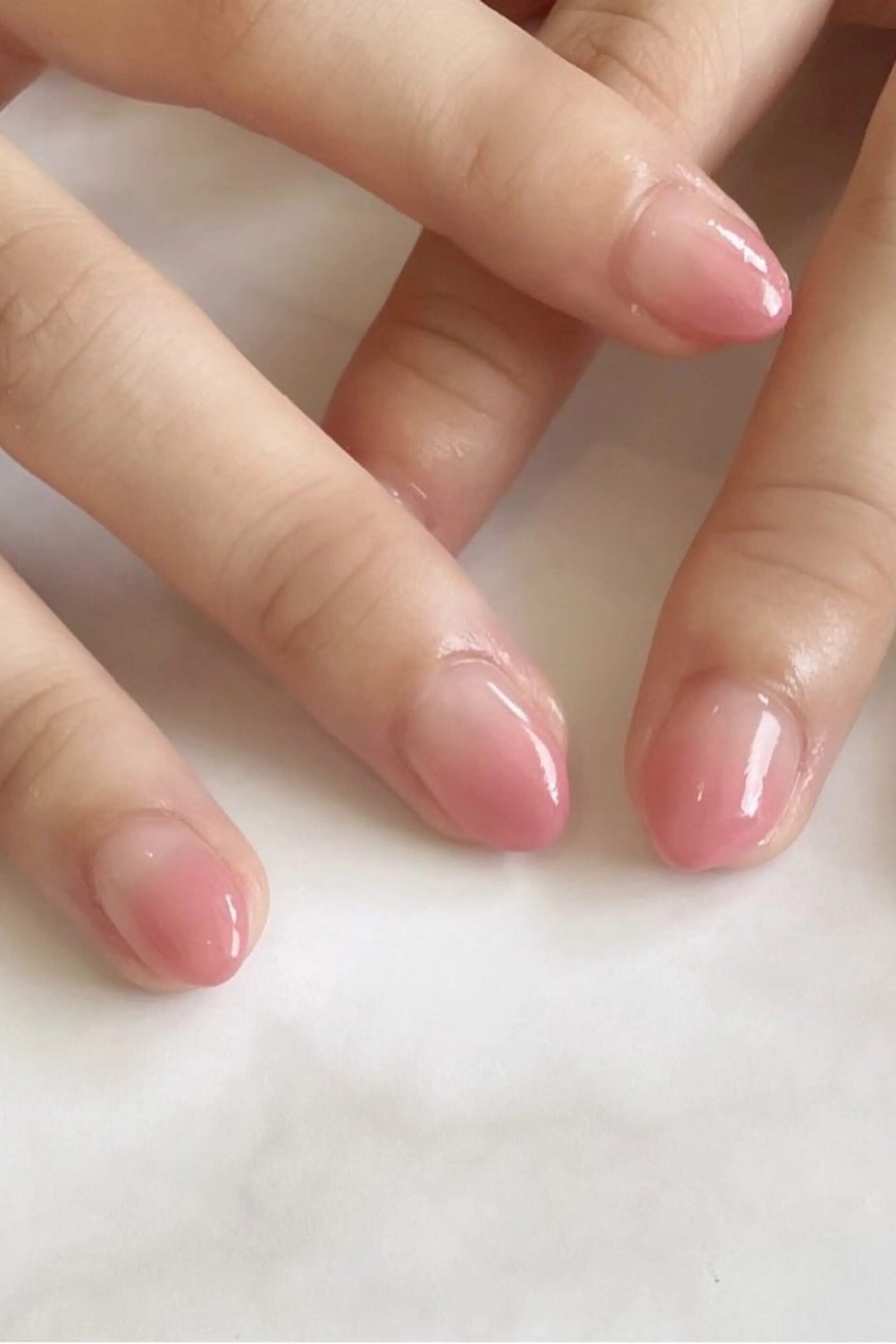short oval, sheer pink, two hands on white surface , for women over 60