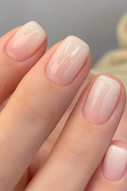 Short nails with milky white ombre fading from pink