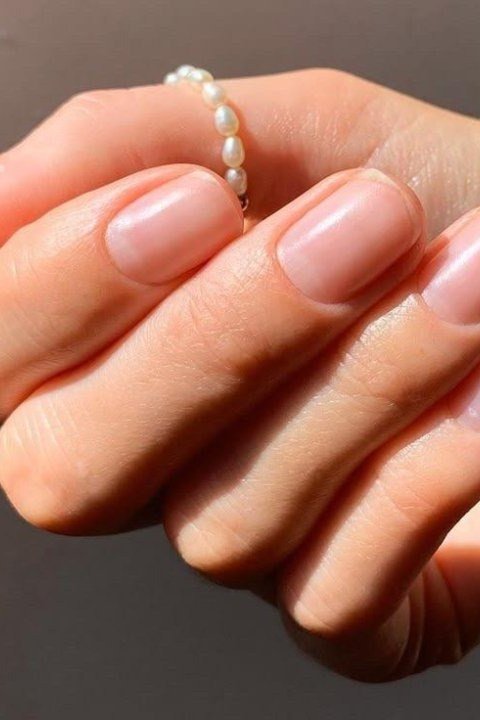 Sheer Pink Nude with a Pearl Bracelet - short nude nail idea for women over 50