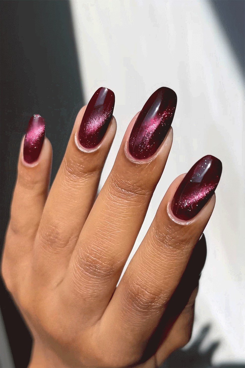 Cat-eye magenta almond, burgundy fall nail idea for women over 60