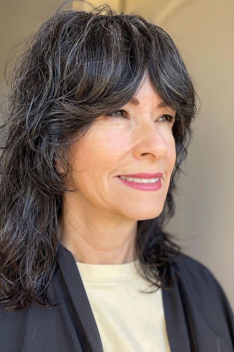 Wavy dark gray hair with bangs on an older woman, front and side view, medium hairstyle for women over 60