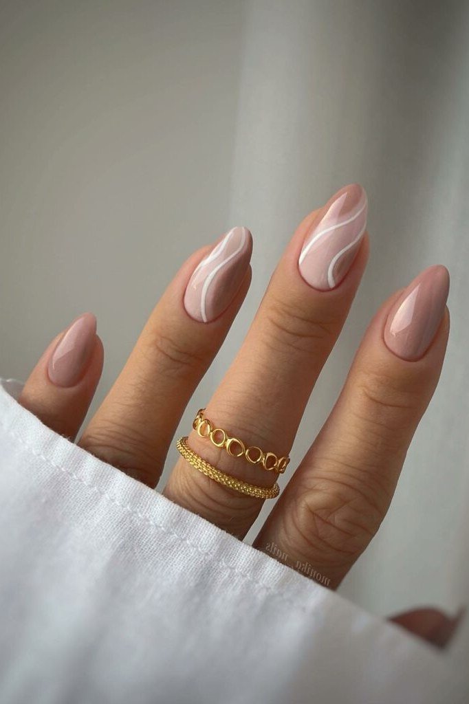 Nude almond gel nails with white swirl lines