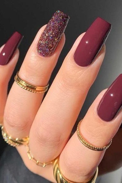 Plum solid with one glitter accent nail, long square, glossy, gold rings, fall nail color for women over 40