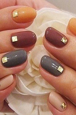 Autumn tone nails with gold stud accents, fall nail design for older women