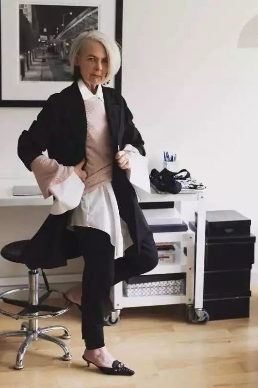 Black blazer with white shirt and black trousers at an office stool