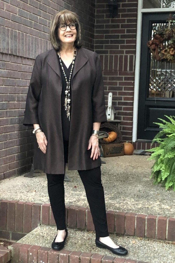 Effortlessly chic fall outfit for women over 60: dark chocolate tunic coat over black trousers