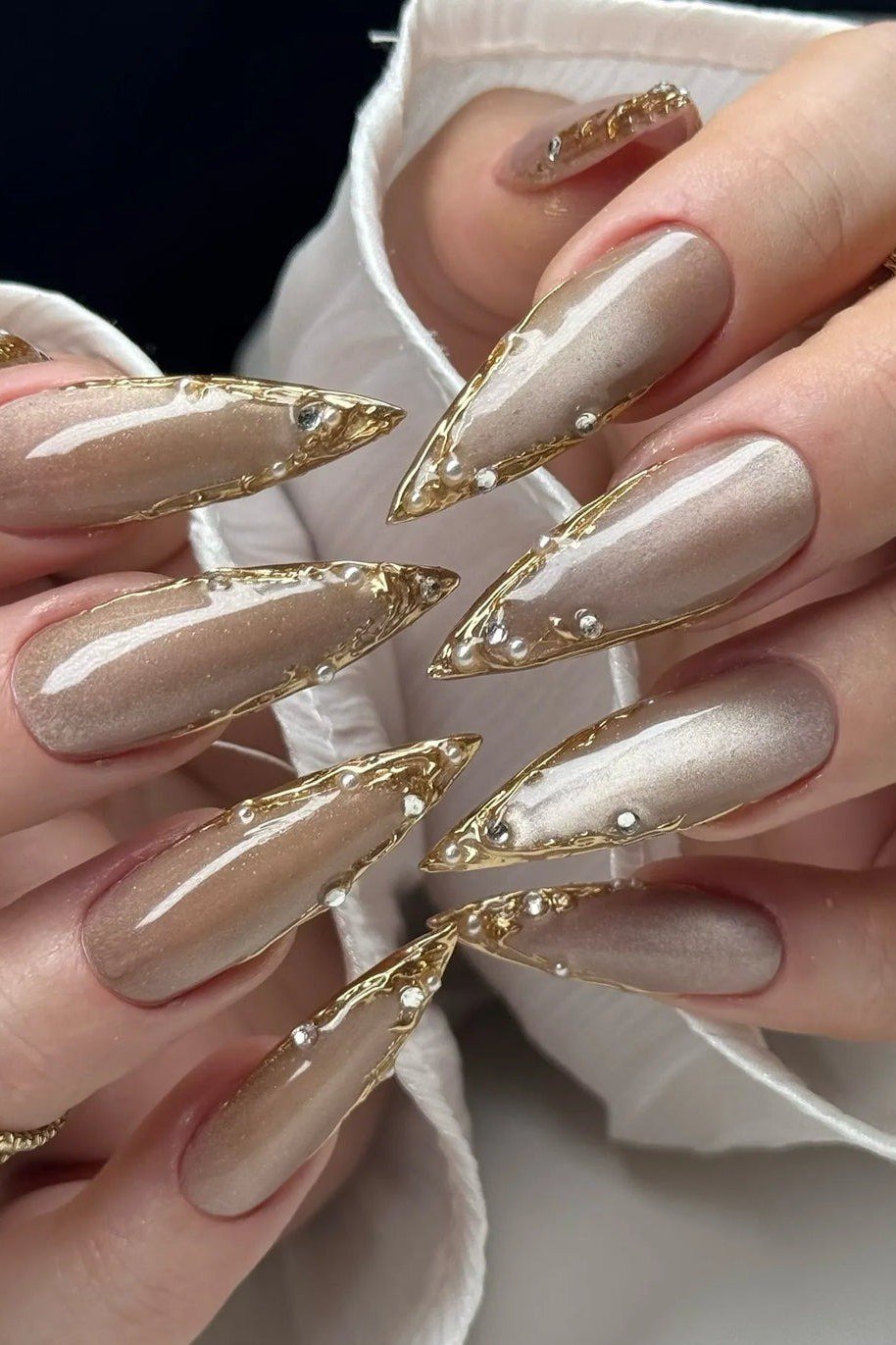 taupe stiletto nails with gold glitter nail art