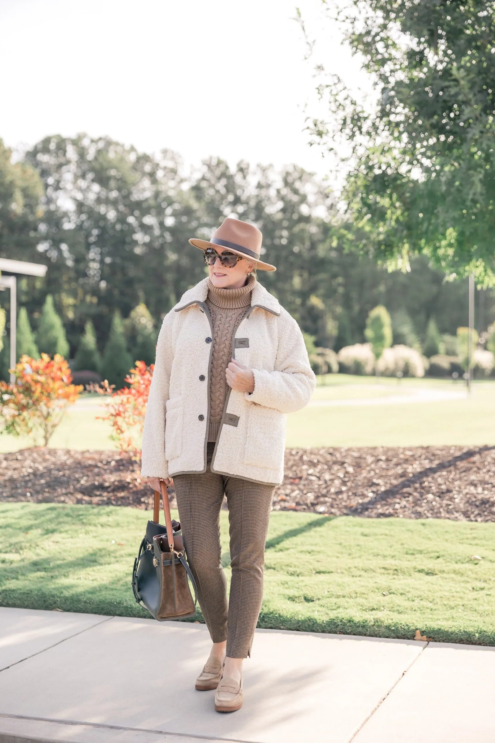 Cream quilted jacket over cream turtleneck with brown trousers, woman over 50