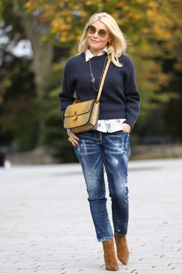 Navy sweater over white shirt with distressed blue jeans, tan ankle boots and tan crossbody