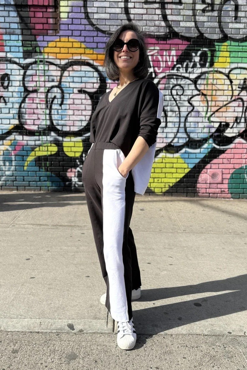Fall city outfit for women over 50: black top black white track pants white sneakers