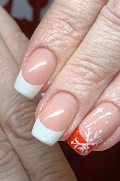 White French tips with red snowflake accent - classy Christmas nail idea for women over 70