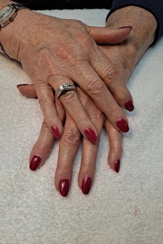 Deep burgundy polish on older hands - classy nail design for older women