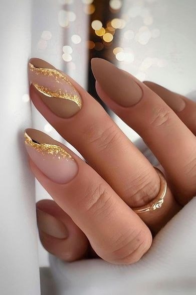 taupe almond nails with gold glitter swirls