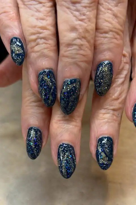 Navy blue glitter nails on mature hands