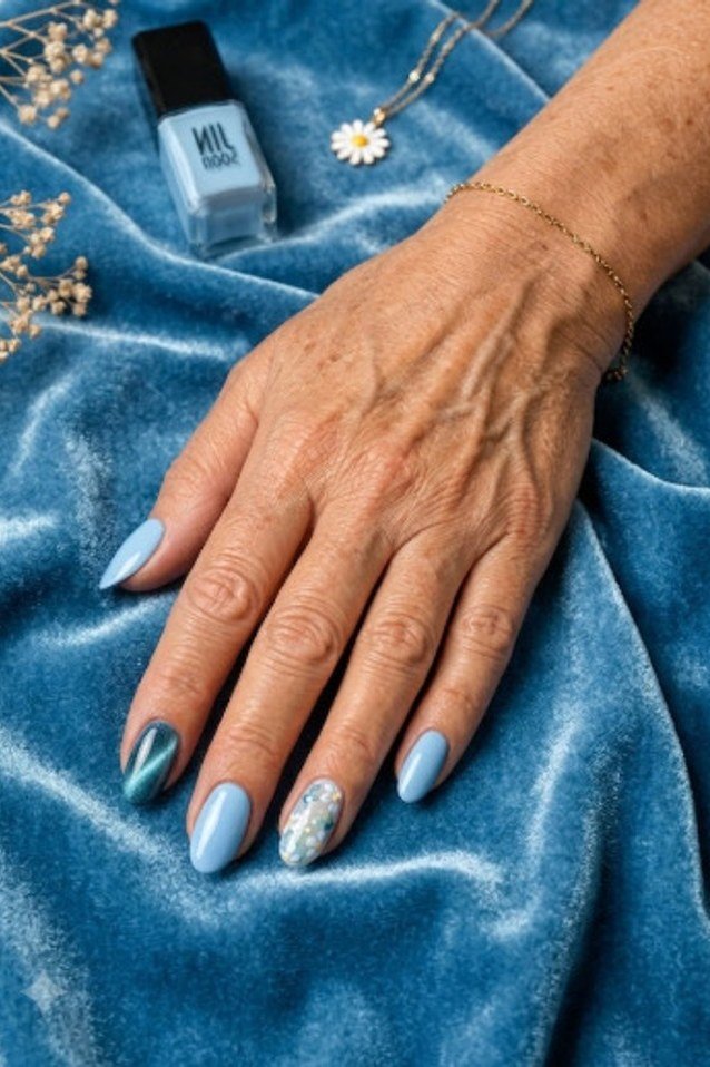 Light blue nails with glitter accent on elderly hand