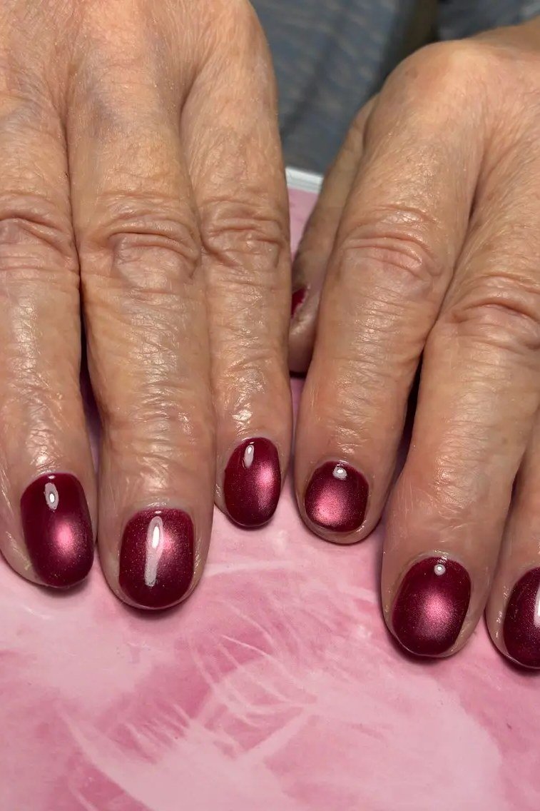 Cranberry Cat Eye Nails - Bright cranberry red with soft magnetic shimmer covers these short, rounded nails.